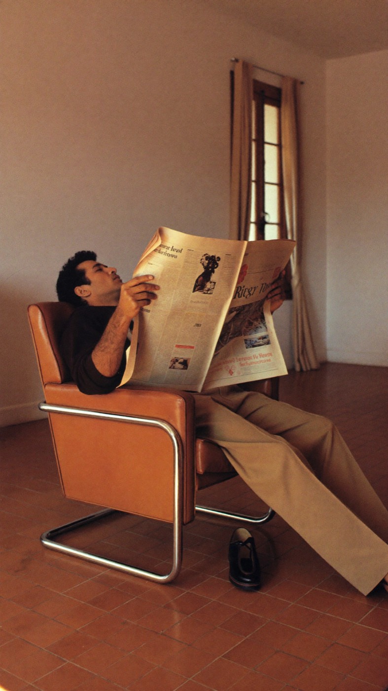 A man reading the paper in a leather armchair